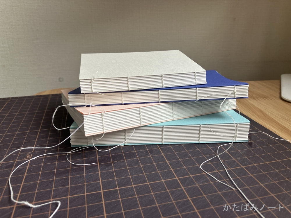 糸かがりのノートが４冊積み重ねてある